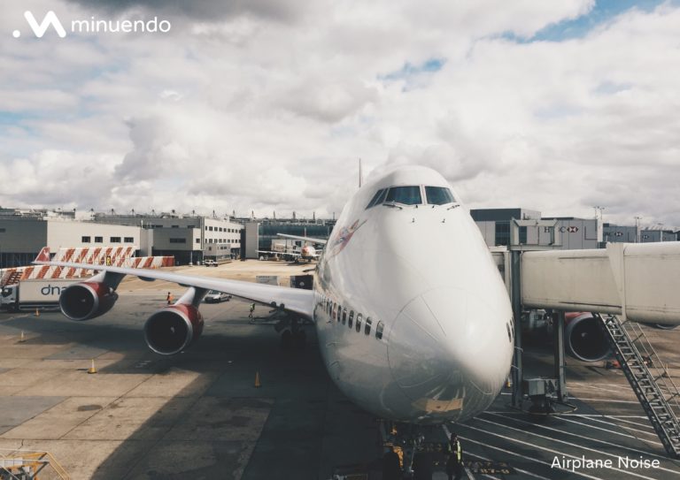 A large airplane parked at an airport, a source of industrial noise.