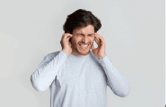 Man grimacing from pain in his ears